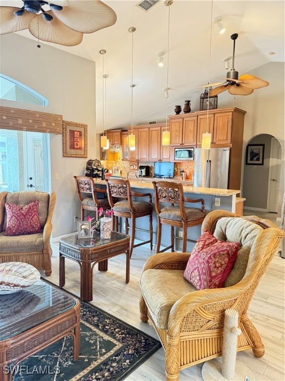 living room featuring ceiling fan and high vaulted ceiling