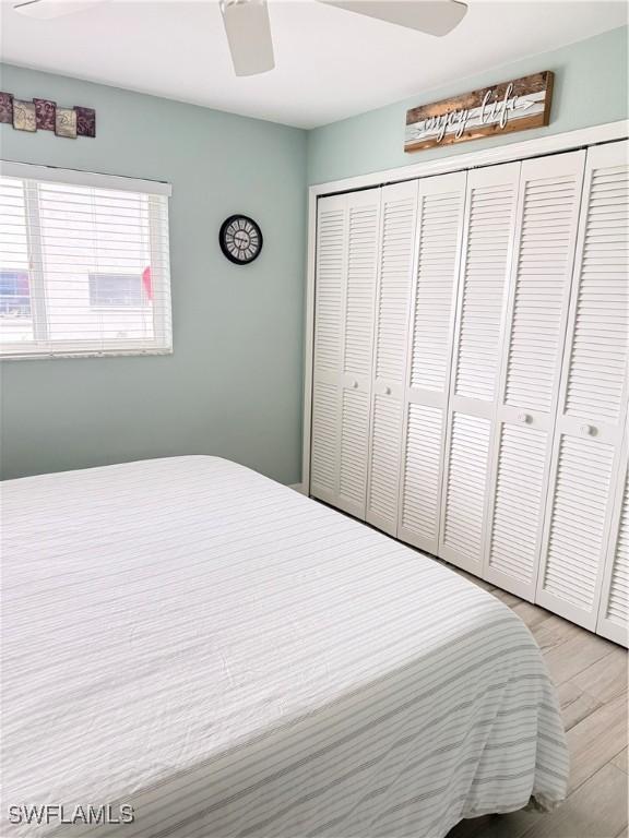 bedroom with ceiling fan, a closet, and light wood-type flooring