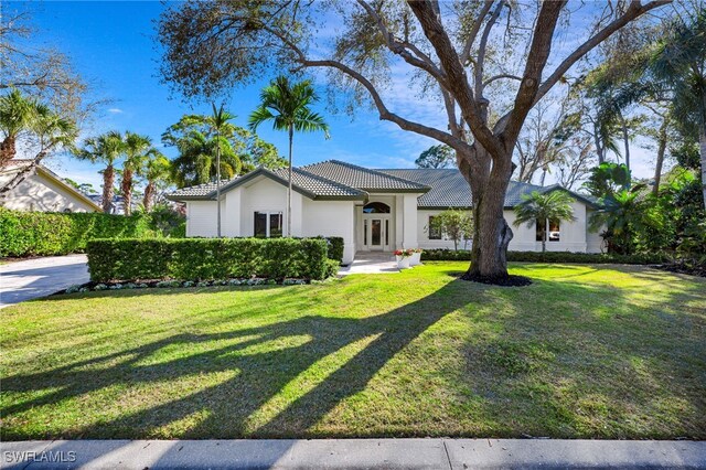 mediterranean / spanish-style home with a front lawn