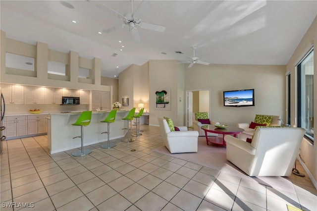 unfurnished living room featuring high vaulted ceiling, ceiling fan, and light tile patterned floors