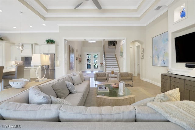 living area featuring arched walkways, visible vents, baseboards, french doors, and ornamental molding