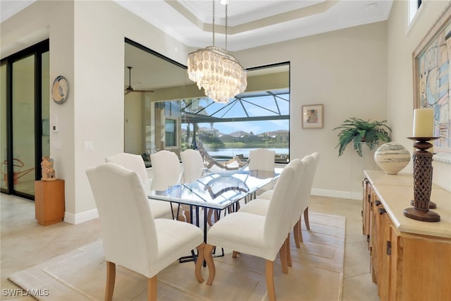 dining space featuring a raised ceiling, a notable chandelier, baseboards, and light tile patterned floors