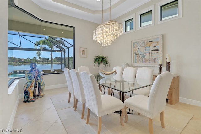 dining area featuring a water view, light tile patterned floors, baseboards, and a wealth of natural light