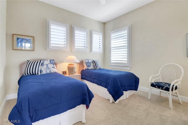 bedroom with light carpet, baseboards, and a ceiling fan