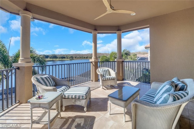 view of patio featuring a balcony, ceiling fan, and a water view