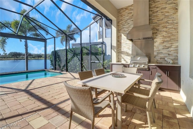 outdoor pool with a patio, exterior kitchen, a water view, and a grill