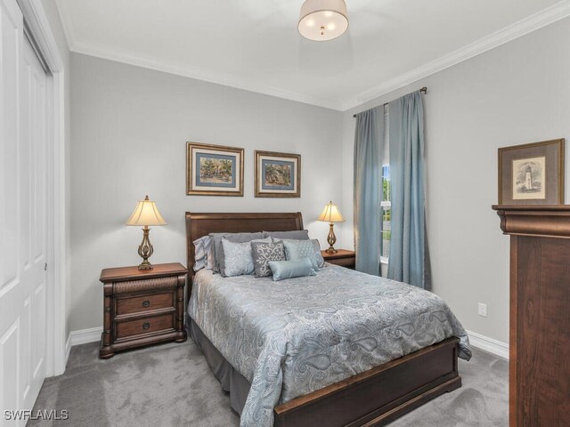 carpeted bedroom with a closet and crown molding