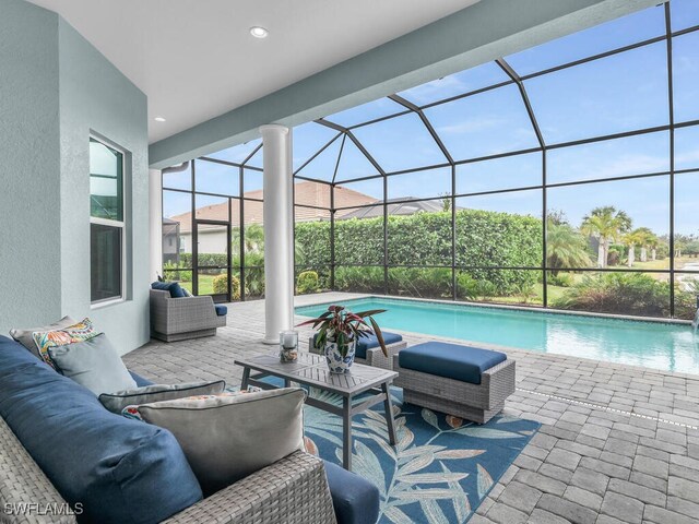 view of swimming pool with a lanai, an outdoor living space, and a patio area