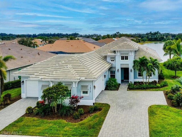 view of front of house featuring a front yard, a garage, and a water view