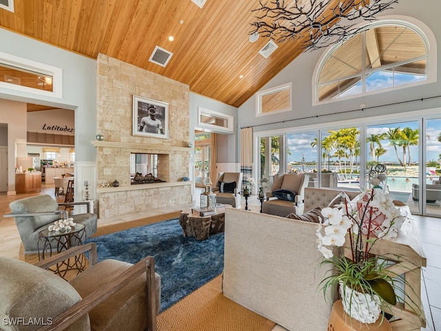 living room with a fireplace, high vaulted ceiling, and wooden ceiling