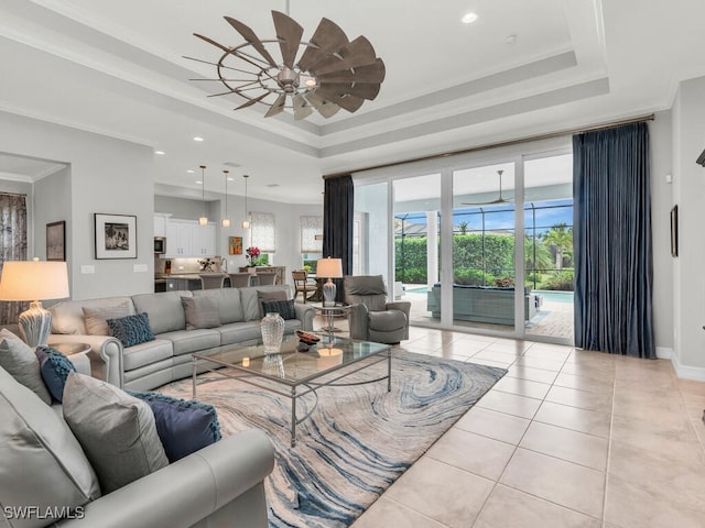 living room featuring a raised ceiling, ornamental molding, light tile patterned flooring, and ceiling fan