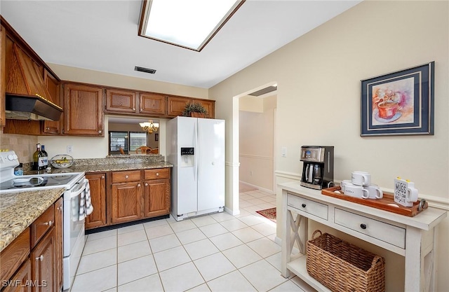 kitchen with white appliances, backsplash, a chandelier, light stone counters, and light tile patterned floors