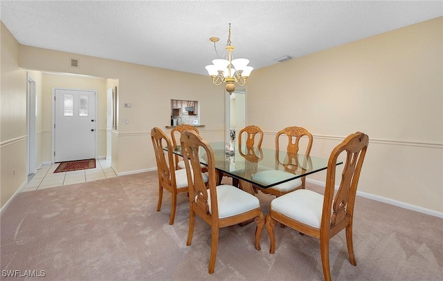 dining area featuring a textured ceiling, light carpet, and an inviting chandelier