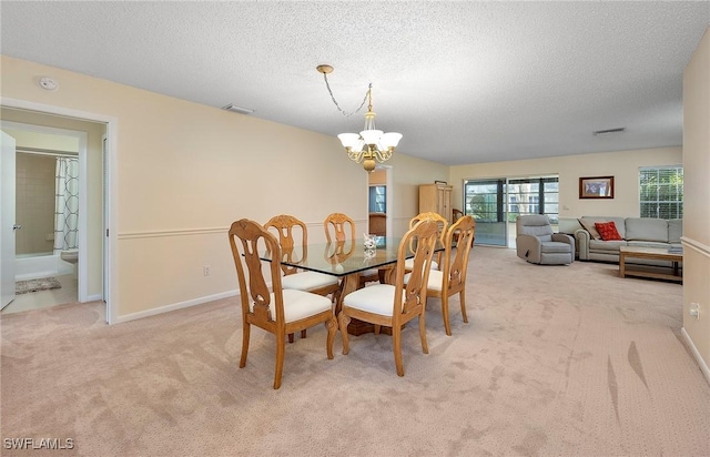 dining area featuring light carpet, an inviting chandelier, and a textured ceiling