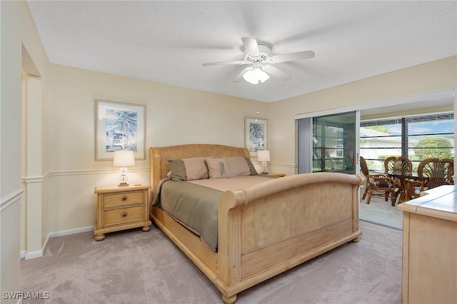 bedroom with light carpet, ceiling fan, access to exterior, and a textured ceiling