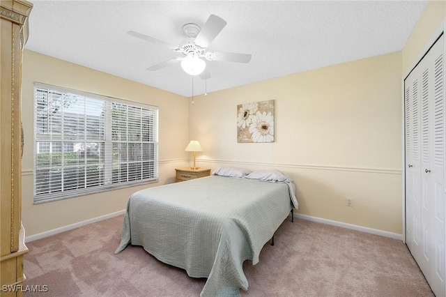 carpeted bedroom featuring ceiling fan and a closet