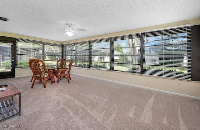 unfurnished sunroom featuring ceiling fan