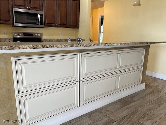 kitchen featuring range and dark brown cabinetry