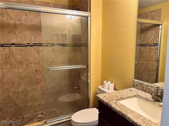 bathroom featuring vanity, toilet, and an enclosed shower