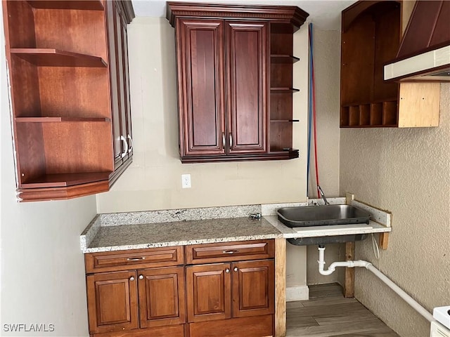 kitchen with premium range hood, hardwood / wood-style floors, and sink