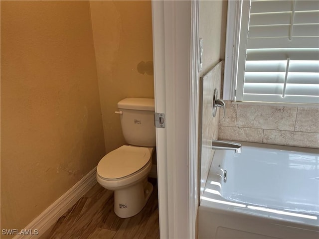 bathroom with hardwood / wood-style floors, toilet, and shower / bathtub combination