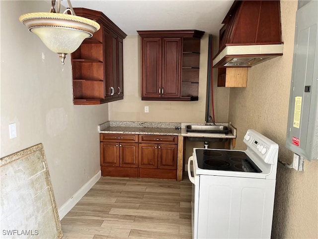 laundry area with light hardwood / wood-style floors, sink, and electric panel