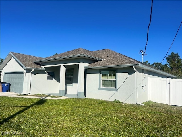 rear view of house featuring a yard and a garage