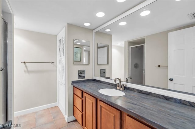 bathroom featuring tile patterned flooring, walk in shower, and vanity