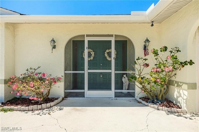 view of exterior entry featuring a patio