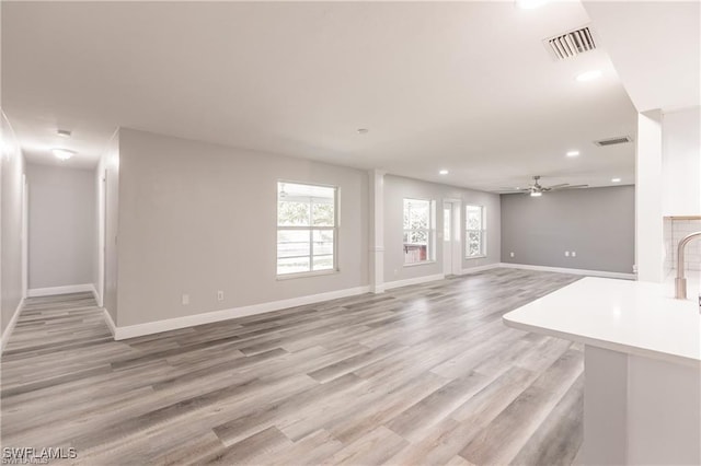 unfurnished living room with light hardwood / wood-style flooring and ceiling fan