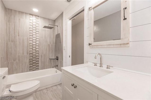 full bathroom with vanity, toilet, and tiled shower / bath