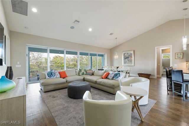 living room featuring plenty of natural light, high vaulted ceiling, and hardwood / wood-style flooring