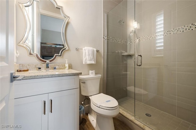 bathroom featuring vanity, toilet, and walk in shower