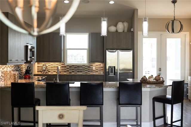 kitchen with dark stone countertops, dark brown cabinetry, and appliances with stainless steel finishes