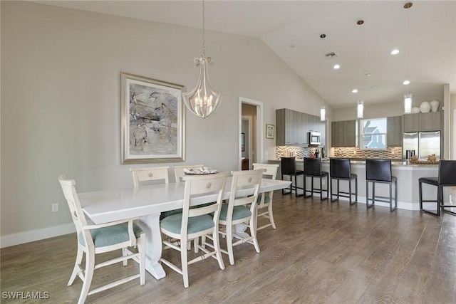 dining area featuring dark hardwood / wood-style flooring, lofted ceiling, and a chandelier