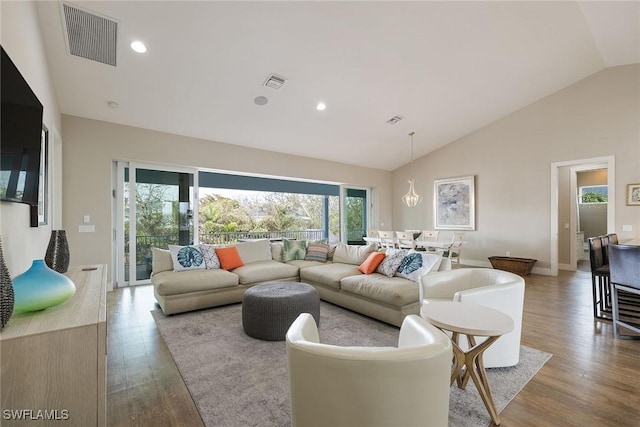 living room featuring light wood-type flooring and vaulted ceiling