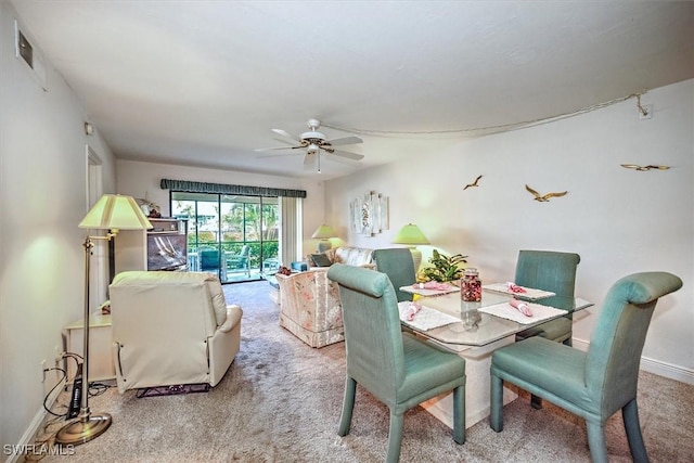 carpeted dining room featuring ceiling fan