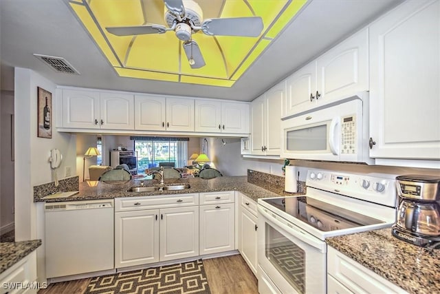 kitchen with white cabinetry, sink, ceiling fan, dark stone counters, and white appliances