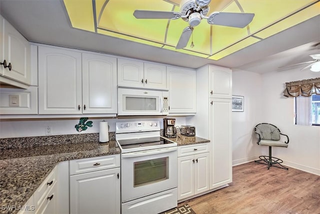 kitchen featuring white appliances, dark stone counters, ceiling fan, light wood-type flooring, and white cabinetry