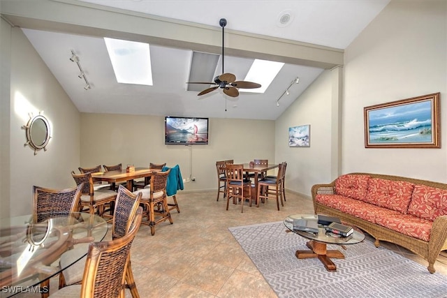 interior space with ceiling fan, lofted ceiling with skylight, light tile patterned floors, and track lighting