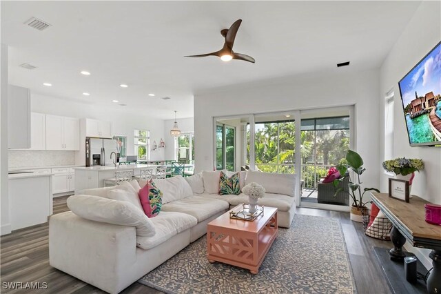 living room with sink, dark hardwood / wood-style flooring, and ceiling fan