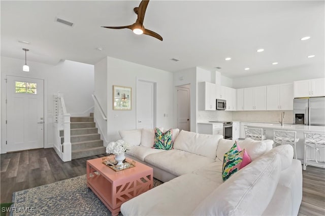 living room featuring ceiling fan and dark hardwood / wood-style floors