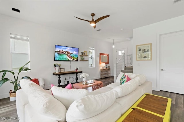 living room featuring dark wood-type flooring and ceiling fan