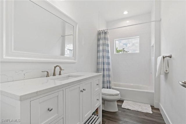 full bathroom featuring vanity, hardwood / wood-style flooring, shower / bath combo with shower curtain, and toilet