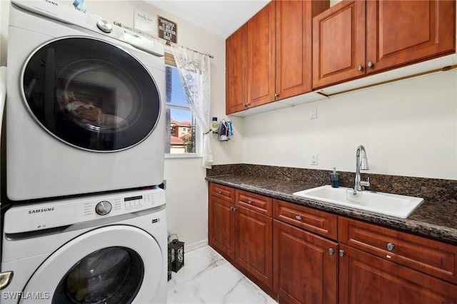 laundry room featuring stacked washer and dryer, marble finish floor, cabinet space, and a sink