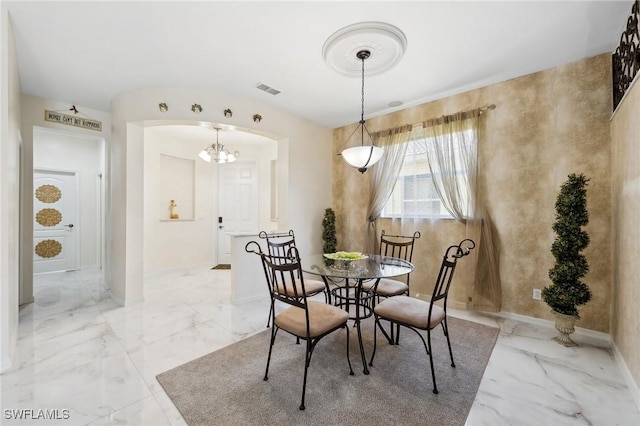 dining room with arched walkways, marble finish floor, visible vents, and baseboards