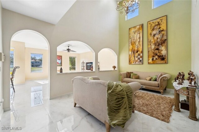10125 N Golden Elm Dr, Estero, FL 33928 - living room featuring arched walkways, a high ceiling, marble finish floor, and ceiling fan with notable chandelier