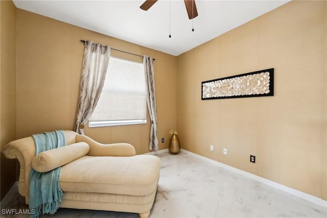 living area featuring ceiling fan and baseboards