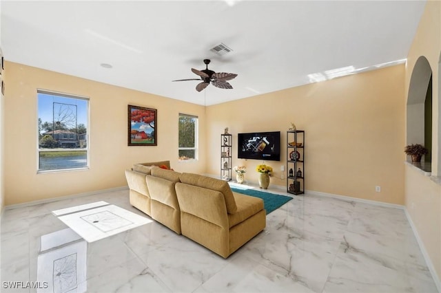 living room featuring marble finish floor, baseboards, visible vents, and a ceiling fan