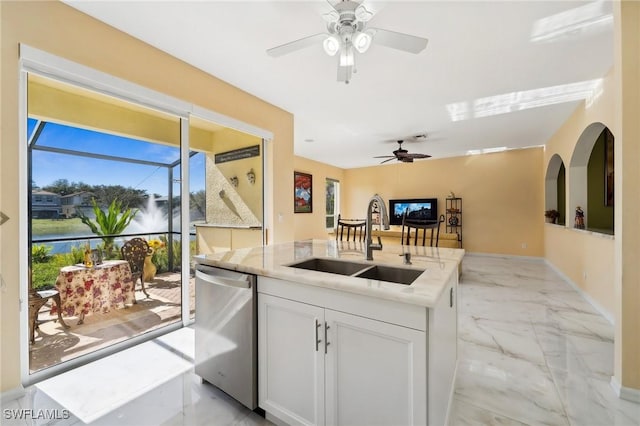 kitchen featuring marble finish floor, a center island with sink, white cabinetry, a sink, and dishwasher